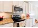 Close up on the kitchen's stainless steel oven and microwave, with granite countertops and white cabinetry at 4557 W South Butte Rd, San Tan Valley, AZ 85144