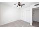 Carpeted bedroom with a ceiling fan, white walls, and a closet with doors that match the trim color at 4902 E Charter Oak Rd, Scottsdale, AZ 85254