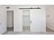Bright bedroom features wood-look floors and a sliding barn door to the walk in closet at 4902 E Charter Oak Rd, Scottsdale, AZ 85254