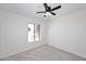 Bedroom with neutral carpet, white walls, a ceiling fan, and a window that provides natural light at 4902 E Charter Oak Rd, Scottsdale, AZ 85254