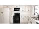 A kitchen with white cabinets, black hardware, stainless steel appliances, and light colored wood look floors at 4902 E Charter Oak Rd, Scottsdale, AZ 85254
