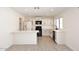 Modern kitchen with white cabinets, a breakfast bar, black appliances, and light wood tile flooring at 4902 E Charter Oak Rd, Scottsdale, AZ 85254