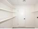 Bright pantry features white walls, light colored wood look tile, a door and several rows of shelves at 4902 E Charter Oak Rd, Scottsdale, AZ 85254