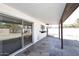 A covered patio features slate flooring and a sliding glass door that leads into the home at 4902 E Charter Oak Rd, Scottsdale, AZ 85254