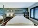 Well-lit bedroom with a large mirror, queen bed, and a dark accent wall at 5122 E Shea Blvd # 1020, Scottsdale, AZ 85254