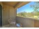 A small patio with a woven outdoor chair and small side table and stucco walls at 5122 E Shea Blvd # 1020, Scottsdale, AZ 85254
