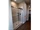 Bathroom featuring a frameless glass shower with marble-look tile surround and a tiled floor at 5633 N 205Th Ln, Buckeye, AZ 85396