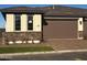 Charming exterior showcasing stone accents, a brown garage door, and a well-manicured lawn at 5633 N 205Th Ln, Buckeye, AZ 85396