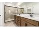 Bathroom with double sink vanity, sleek fixtures, and a glass-enclosed shower at 5641 N 205Th Ln, Buckeye, AZ 85396