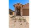 Home entrance featuring an arched entryway with ample lighting and desert landscaping at 5641 N 205Th Ln, Buckeye, AZ 85396