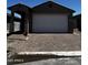 Charming home featuring a paved driveway, two-car garage, and covered portico at 5641 N 205Th Ln, Buckeye, AZ 85396