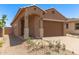 Inviting home featuring an arched entryway, desert landscaping, and a spacious two-car garage at 5641 N 205Th Ln, Buckeye, AZ 85396