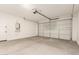Spacious garage with concrete flooring, overhead door, and utility connections, ideal for parking and storage at 5641 N 205Th Ln, Buckeye, AZ 85396