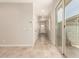 Bright hallway with tile flooring, closet doors, and a sliding glass door leading to the backyard at 5641 N 205Th Ln, Buckeye, AZ 85396