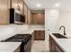 Well-lit kitchen featuring stainless steel appliances, light countertops, and stylish cabinets at 5641 N 205Th Ln, Buckeye, AZ 85396