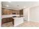 Kitchen with a center island, white countertops, modern appliances, and dark cabinets at 5641 N 205Th Ln, Buckeye, AZ 85396