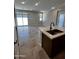 Open floor plan with a kitchen island that features a stainless sink at 5641 N 205Th Ln, Buckeye, AZ 85396