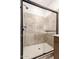 Modern walk-in shower with glass door, tiled walls, and white-tiled floor at 5641 N 205Th Ln, Buckeye, AZ 85396