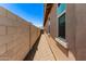 The side yard presents a rock-covered landscape along a block wall, providing a walkway to the backyard at 5641 N 205Th Ln, Buckeye, AZ 85396