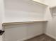 Spacious walk-in closet with white walls and wooden hanging rods for ample storage at 5641 N 205Th Ln, Buckeye, AZ 85396