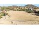 Expansive aerial view of vacant land with mountain views and scattered vegetation near a residential area at 6506 W Bent Tree Dr, Phoenix, AZ 85083