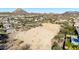 Expansive aerial view of vacant land with mountain views and scattered vegetation near a residential area at 6506 W Bent Tree Dr, Phoenix, AZ 85083