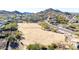 Expansive aerial view of vacant land with mountain views and scattered vegetation near a residential area at 6506 W Bent Tree Dr, Phoenix, AZ 85083