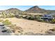 Expansive aerial view of vacant land with mountain views and scattered vegetation near a residential area at 6506 W Bent Tree Dr, Phoenix, AZ 85083