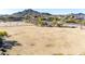 Expansive aerial view of vacant land with mountain views and scattered vegetation near a residential area at 6506 W Bent Tree Dr, Phoenix, AZ 85083