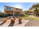 Inviting backyard featuring a custom fire pit, seating logs, green grass, covered patio and a play structure at 6506 W Bent Tree Dr, Phoenix, AZ 85083