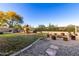 Large backyard featuring a play area, a fire pit with stump seating, and well-maintained landscaping at 6506 W Bent Tree Dr, Phoenix, AZ 85083