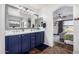 Bathroom featuring double sink vanity with blue cabinets and access to main bedroom at 6506 W Bent Tree Dr, Phoenix, AZ 85083