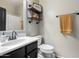Bathroom with modern sink and faucet, open shelving with rolled towels, and neutral wall color at 6506 W Bent Tree Dr, Phoenix, AZ 85083