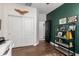 Stylish room with hardwood floors, closet, contrasting green wall, and a shelf displaying decorative items at 6506 W Bent Tree Dr, Phoenix, AZ 85083