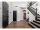 Spacious entryway featuring warm laminate flooring, and a staircase with black accents at 6506 W Bent Tree Dr, Phoenix, AZ 85083