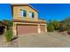 View of the exterior featuring the two-car garage, spacious driveway, and low maintenance desert landscaping at 6506 W Bent Tree Dr, Phoenix, AZ 85083