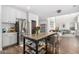 Modern kitchen featuring stainless steel appliances and a center island with bar stool seating and hardwood flooring at 6506 W Bent Tree Dr, Phoenix, AZ 85083