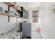 Functional laundry room with modern washer and dryer, patterned tile flooring, and shelving for storage at 6506 W Bent Tree Dr, Phoenix, AZ 85083