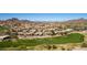 Aerial view of golf course community with lush fairways and luxury homes against mountain backdrop at 6520 E Sugarloaf St, Mesa, AZ 85215