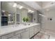Bright bathroom with double sinks, quartz countertops, decorative mirror and large, glassed-in shower at 6520 E Sugarloaf St, Mesa, AZ 85215