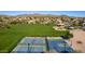Aerial shot of community tennis and basketball courts set among landscaped homes with mountain views at 6520 E Sugarloaf St, Mesa, AZ 85215