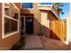 Inviting entryway with a dark front door, wood gate, desert landscaping, and a stylish exterior at 6520 E Sugarloaf St, Mesa, AZ 85215