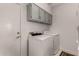Functional laundry room with newer washer and dryer with overhead cabinet storage at 6520 E Sugarloaf St, Mesa, AZ 85215