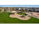 Aerial view of community playground with play structures and shaded seating surrounded by lush green grass at 6520 E Sugarloaf St, Mesa, AZ 85215