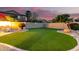 Backyard with a well-manicured lawn, rock decorations, and a concrete block wall at 69 E Benrich Dr, Gilbert, AZ 85295