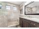 Beautiful bathroom with stone tile shower, pebble floor, rain shower head, and dark wood vanity at 69 E Benrich Dr, Gilbert, AZ 85295
