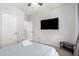 Bedroom featuring a ceiling fan, TV, and double-door closet with adjoining bathroom at 69 E Benrich Dr, Gilbert, AZ 85295