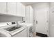 Bright laundry room features a modern washer and dryer set, white cabinets, and a convenient exterior door at 69 E Benrich Dr, Gilbert, AZ 85295