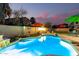 Backyard with a pool, waterfall feature, and various patio seating areas at 69 E Benrich Dr, Gilbert, AZ 85295