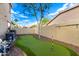 Backyard putting green is surrounded by mature landscaping, with a beautiful shade tree at 69 E Benrich Dr, Gilbert, AZ 85295